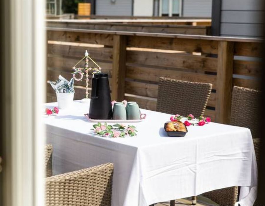 Somrig dukning med fika och midsommarstång på uteplats i stuga i Ängelholm